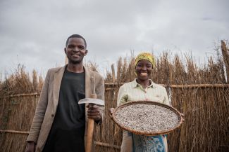 A couple stands together showing their sunflower seeds harvest