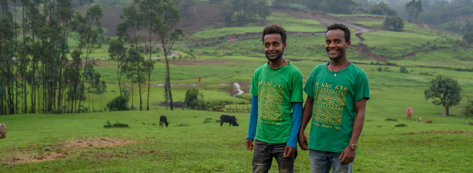 Two One Acre Fund Ethiopia staff members stand in the field 