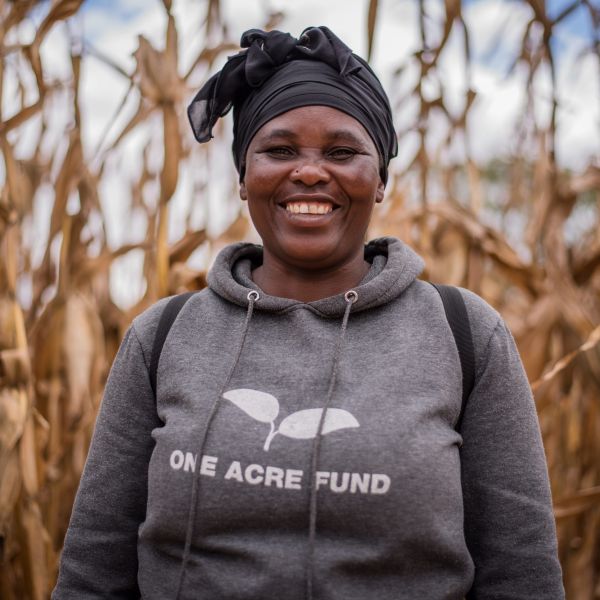 A One Acre Fund staff member smiles in her One Acre Fund hoodie